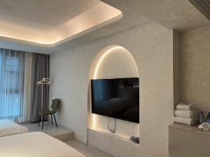 西安忆宿石玖设计师酒店(西安钟鼓楼回民街店)的卧室设有壁 ⁇ 内的电视