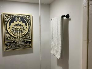 墨西哥城Cozy Condesa的浴室墙上有照片,配有毛巾