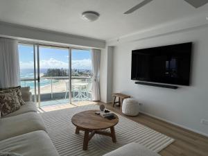 黄金海岸Endless Summer in Cooly Level 18的带沙发、电视和桌子的客厅