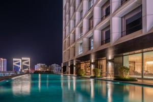 海口海口索菲特酒店的一座游泳池,在晚上在建筑物前