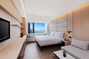 上海大都会海逸公寓的一间酒店客房,配有一张床和一台电视