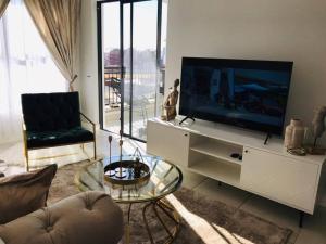 比勒陀利亚Luxury beach lagoon 1 Bedroom apartment的客厅配有白色橱柜上的平面电视