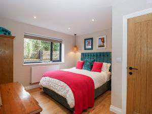 LonghopeSevenwoods View的一间卧室配有一张带红色和蓝色枕头的床