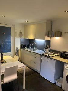 埃因霍温Jaguars Residence的厨房配有白色橱柜、桌子和水槽。