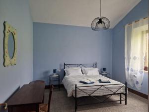 圣奎里科-多尔恰罗瑟洛农场酒店的蓝色卧室,配有床和桌子