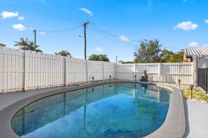 Pialba4 Bedroom Getaway with Pool的白色围栏前的游泳池