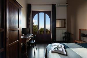 拉加尔纳多莫斯维迪安娜住宿加早餐旅馆的一间卧室配有一张床、一张书桌和一个窗户。