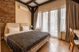 伊斯坦布尔卡兰泽公寓酒店的一间卧室设有一张床和砖墙