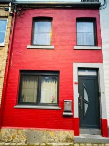 瑟兰Bien-être-Au-calme et parking gratuit的红色的房子,有黑色的门和窗户