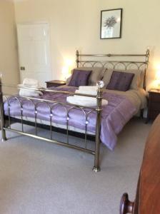 北查尔顿岩沼屋住宿加早餐旅馆的一间卧室配有一张紫色床单的床