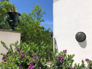 曼杜里亚Antica Casa del Pozzo的种有紫色花卉和围栏的花园
