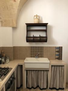 曼杜里亚Antica Casa del Pozzo的厨房配有水槽和炉灶