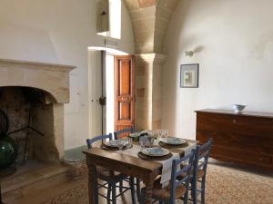 曼杜里亚Antica Casa del Pozzo的一间带桌椅和壁炉的用餐室