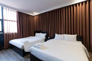 胡志明市Queen Central Hotel - Ben Thanh Market的酒店客房设有两张床和窗户。