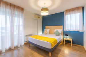 图卢兹Appart'City Confort Toulouse Purpan的一间卧室配有一张蓝色墙壁的床