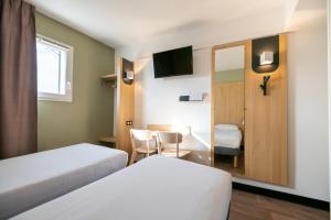 梅里尼亚克B&B HOTEL Bordeaux Mérignac Aéroport的酒店客房,设有两张床和镜子