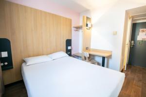 梅里尼亚克B&B HOTEL Bordeaux Mérignac Aéroport的卧室配有白色的床和书桌