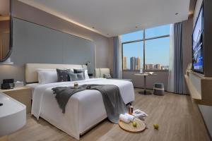 广州诗贝酒店的卧室设有一张白色大床和大窗户