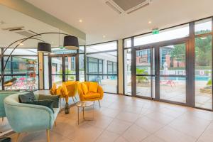 图卢兹Appart'City Confort Toulouse Purpan的客厅设有黄色椅子和滑动玻璃门