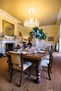 AstleySevern Manor的用餐室配有长桌子、椅子和吊灯