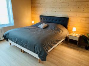 克松吕-隆日梅※ Résidence POMME DE PIN - Terrasse - Nature ※的一间卧室配有一张带蓝色棉被的大床
