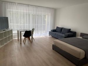 巴登-巴登威斯塔特公寓的一间卧室配有一张床、一张桌子和一张沙发