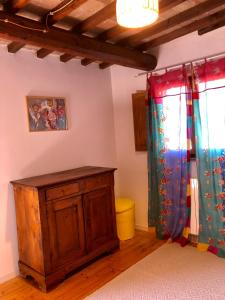 蒙特罗尼德阿尔比亚特努卡迪科萨诺酒店的一间设有两把窗帘和木柜的房间
