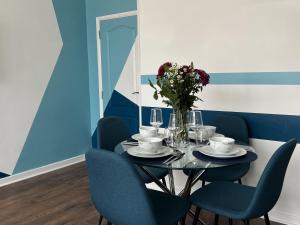 滨海韦斯特克利夫Modern accomodation in Westcliff-On-Sea的一间带桌子和蓝色椅子的用餐室