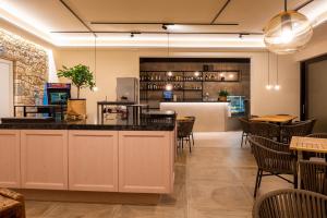 托里德尔贝纳科Relais Limonaia - Suites & Garden SPA的餐厅设有酒吧和桌椅