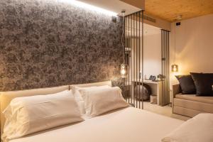 托里德尔贝纳科Relais Limonaia - Suites & Garden SPA的卧室配有白色的床和沙发