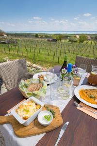 TagyonTagyon Birtok Mandula Apartmanház的餐桌,带食物,享有葡萄园的景色