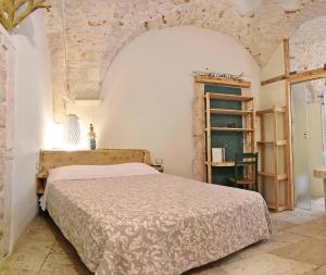 普蒂尼亚诺l'angolo di Gaudì, alcoba Blanca的一间卧室设有一张床和石墙