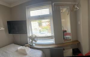 TevershamRoom in family home的一间卧室配有一张床和一个带风扇的窗户。