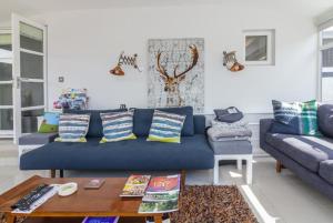 道格拉斯Rivendell Cottage的客厅配有蓝色的沙发和桌子