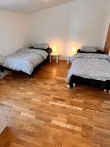 马尔默HBA Appartsments的客房设有两张床,铺有木地板。