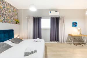 巴里Sunny Beach Bari的一间卧室配有一张床、一张桌子和一个窗户。