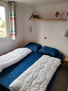 劳雷尔苏格BJ Chalets - Robbengat 85 - Gezellige, kindvriendelijke chalet op vakantiepark Lauwersoog! Vroege incheck!的一间卧室设有两张床和窗户。