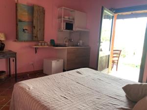 特乌拉达Amalfatah的一间卧室配有一张床铺和一张桌子,还设有一间厨房