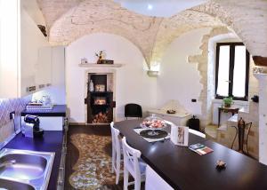 普蒂尼亚诺L'Angolo di Gaudì, casa Milà的一间厨房,内设桌子和壁炉