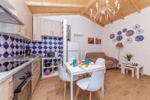 布德恩斯B54 - Casa Azul in Burgau的厨房以及带白色桌椅的用餐室。