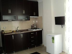 锡德ELSİRA APART的厨房配有黑色橱柜和白色冰箱。