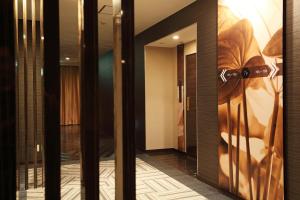 富山ホテルウォーターゲート富山 レジャーホテル 大人用ホテル的墙上挂着一幅画作的门的房间