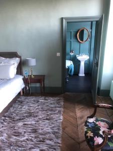 Bois-Normand-près-Lyre红房子旅馆的一间卧室配有床、水槽和镜子