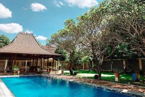TimuranTirtodipuran Hotel Yogyakarta的房屋前的游泳池