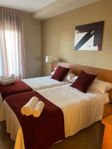 PomarEL RINCON DE TOÑO的两间相邻的床铺位于酒店客房内
