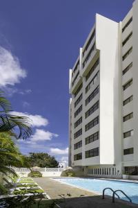 圣多明各圣多明各雷迪森酒店的一座白色的大建筑,前面设有一个游泳池