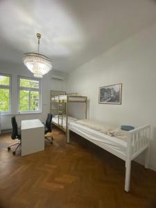 卢布尔雅那Rooms Miklošičeva的一间卧室配有一张床、一张书桌和一个吊灯。