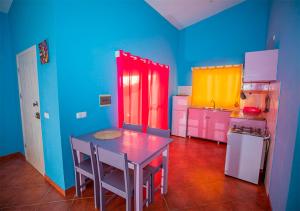 马约城Villa Lagosta Stella Maris Exclusive的厨房拥有色彩缤纷的墙壁、桌子和冰箱