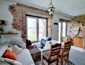 ŠvenčionysGluosnių vila - Adutiškio pirtis的客厅配有带笔记本电脑的桌子