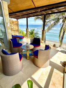 甘地达萨Ocean Suite By A&J - Exceptional Beachfront Apartment - Candidasa的一个带桌椅的庭院和海滩